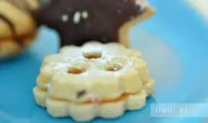 Konfitüre getrennt in einem Topf erwärmen, abwechselnd einen Klecks in die Mulden der Kekse füllen
