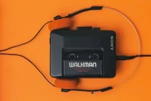 Ein Kassettenrekorder mit Kopfhörern auf orangefarbenem Hintergrund.